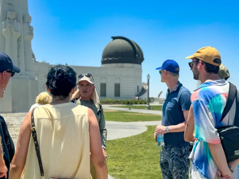 Travelers enjoying a scenic Bikes and Hikes LA city tour through the lush, green hills of Griffith Park during the summer season.