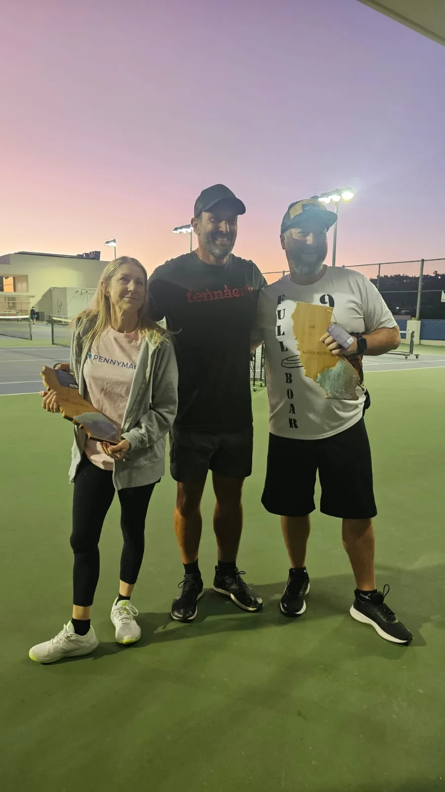 Winners pose with their trophies after a pickleball tournament