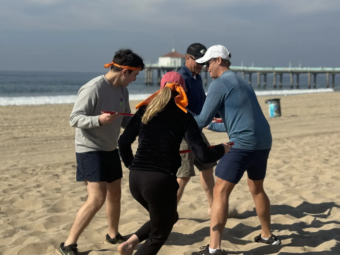 A team hustles on the beach playing a team building game