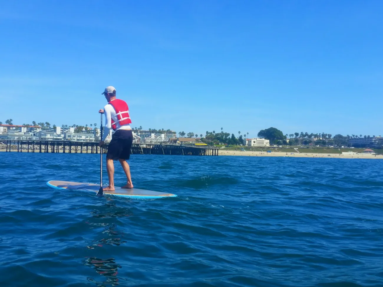 A guest rides a paddleboard on the ocean