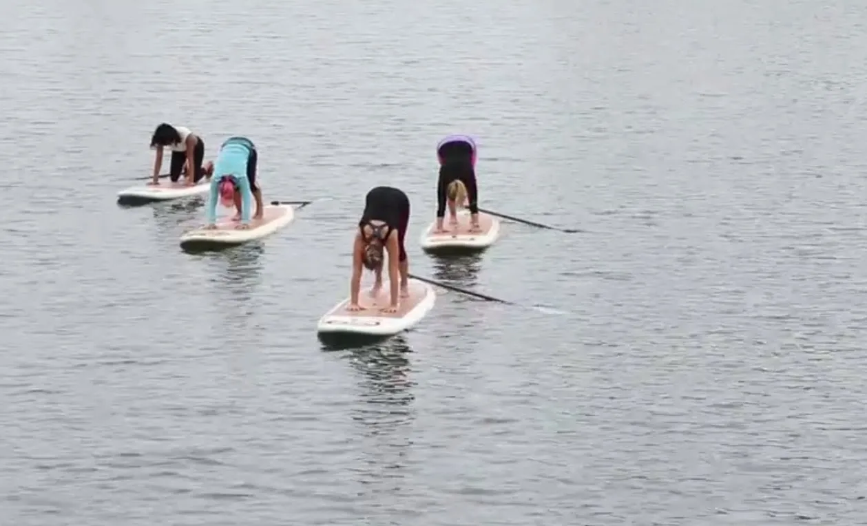 Guests do yoga on paddleboards in the ocean