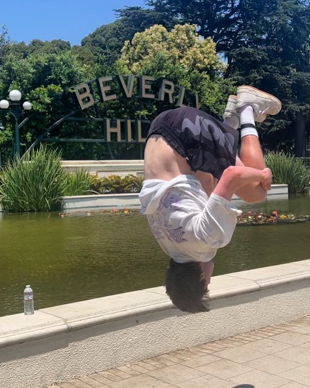 A guest on the Beverly Hills Tour Flips at the Beverly Hills Sign