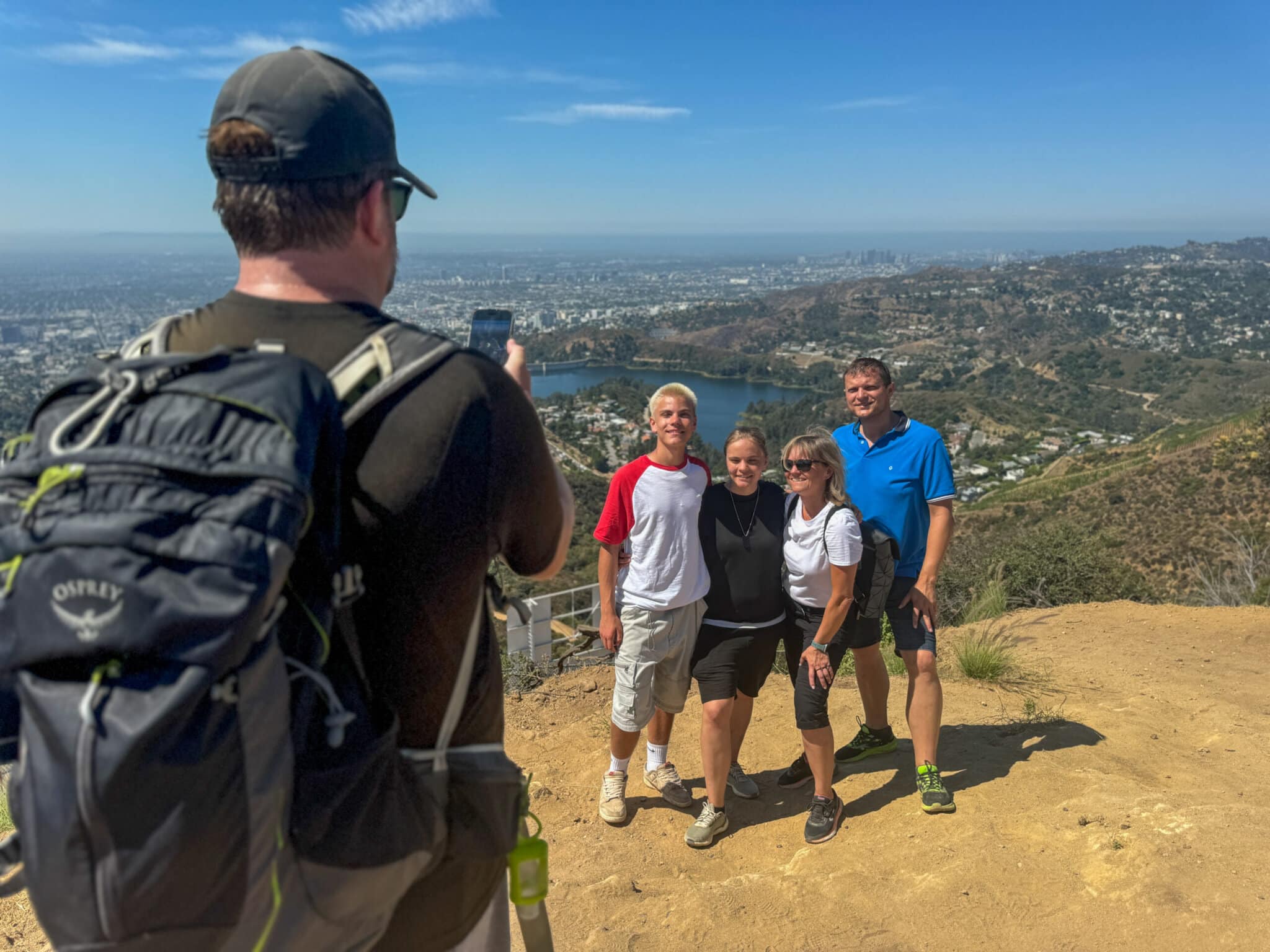 A guide takes a family photo at the top of the Hollywood Sign Hike