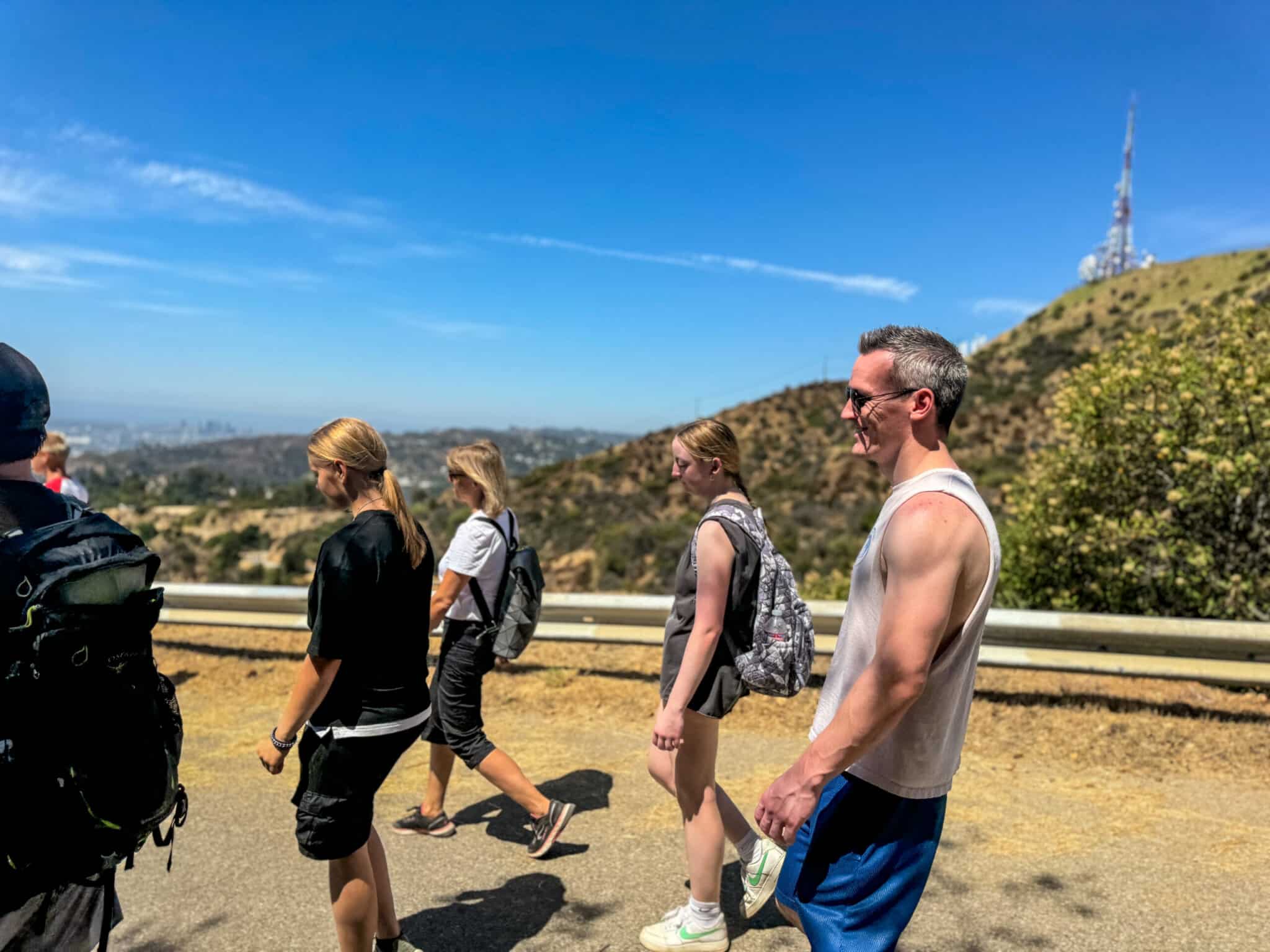 A group of people walk down the hill on the Hollywood Sign Tour
