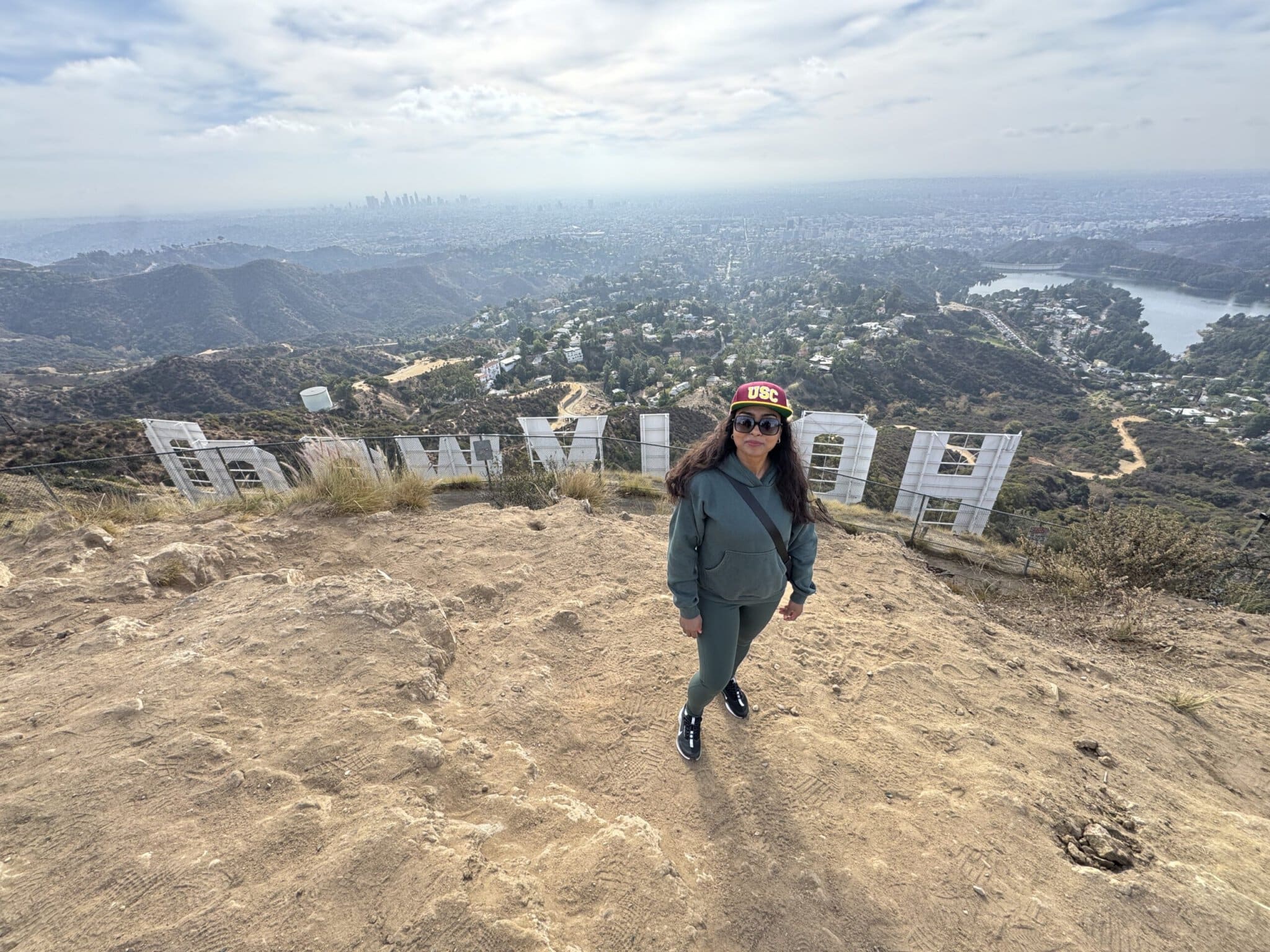 A guest stands at the top of the Hollywood Sign Hike