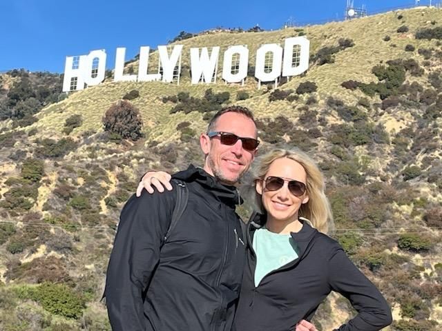 Guests pose under the Hollywood Sign on the Hollywood Sign Tour