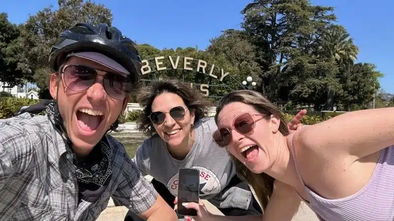 Guests smile in front of the Beverly Hills Sign