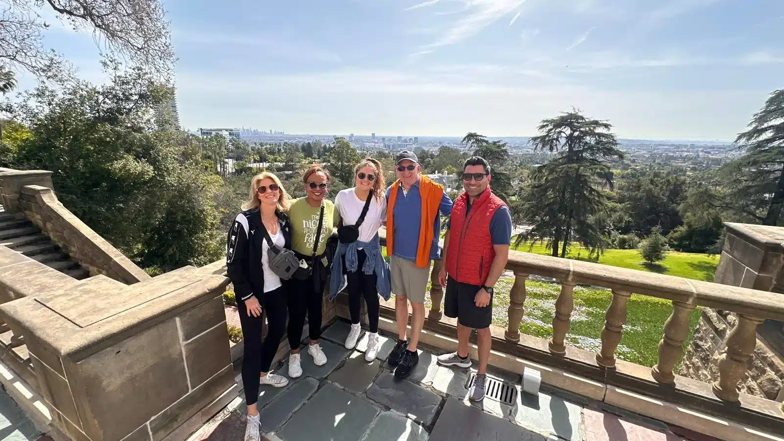 Guests pose overlooking downtown Los Angeles on the Beverly Hills Tour