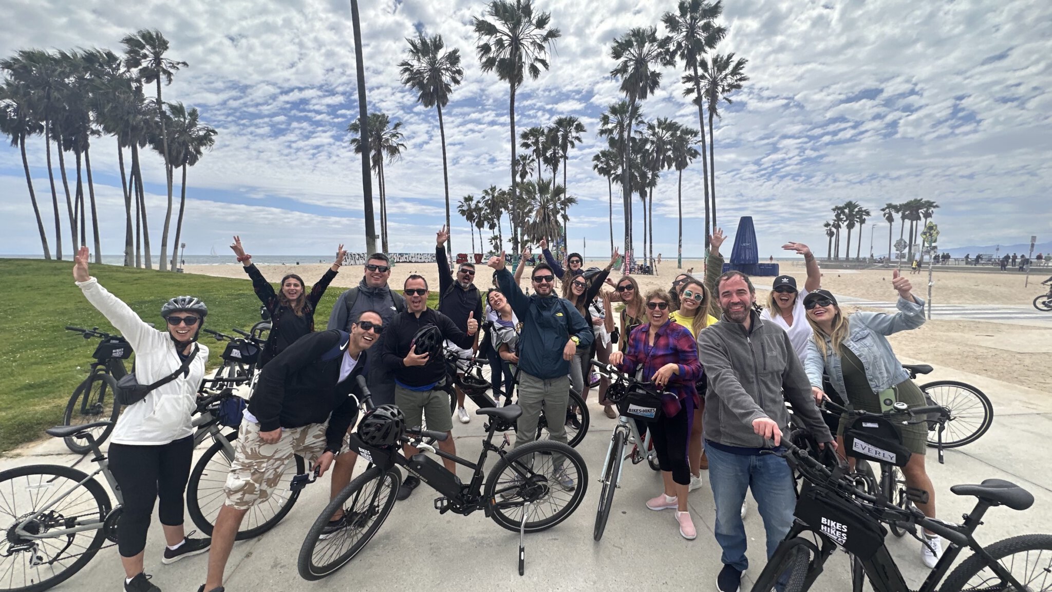 A group cheers in front of Venice Beach on the Santa Monica and Venice Beach Bike Tour
