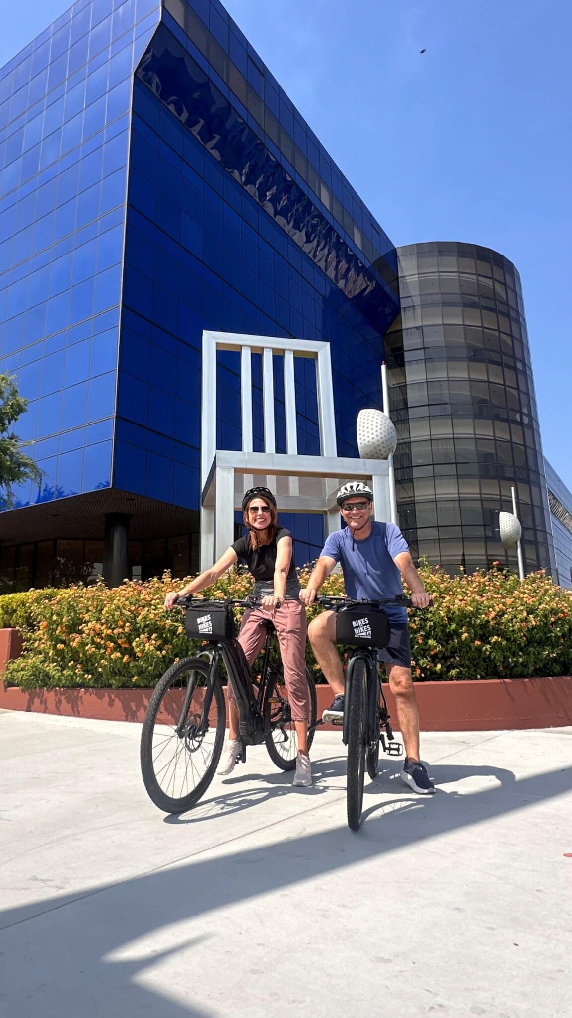 Guests on the West Hollywood Bike Tour pose in front of artwork outside of the Pacific Design Center