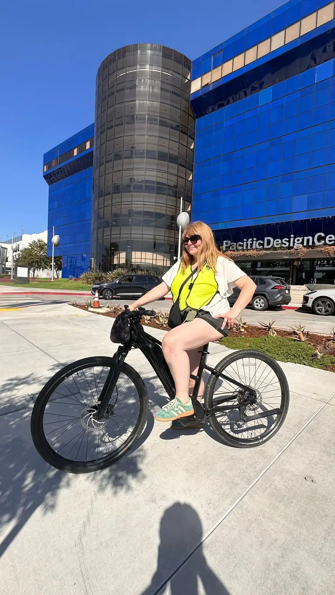 A guest poses on her bike in front of the Pacific Design Center on the West Hollywood Bike Tour