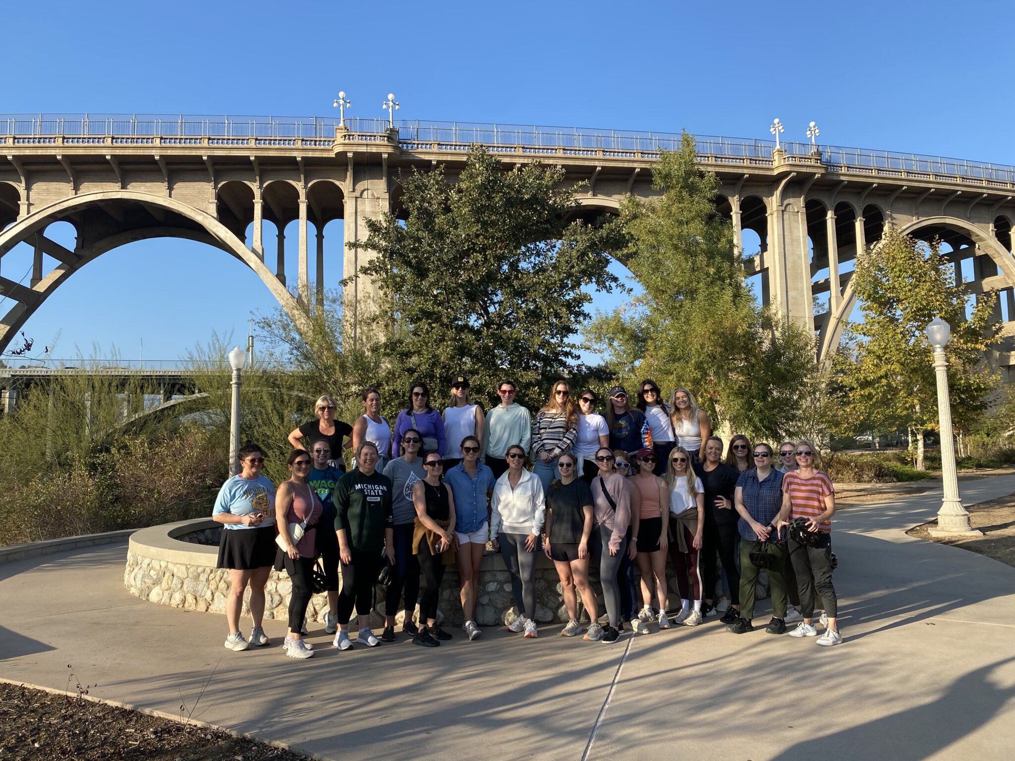 A group poses in front of the Colorado Street Bridge in Pasadena