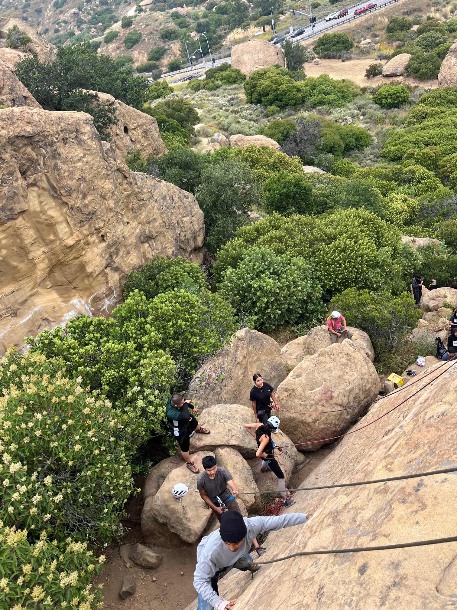 A group stands at the base of the rocks during a rock climbing experience with Bikes and Hikes LA