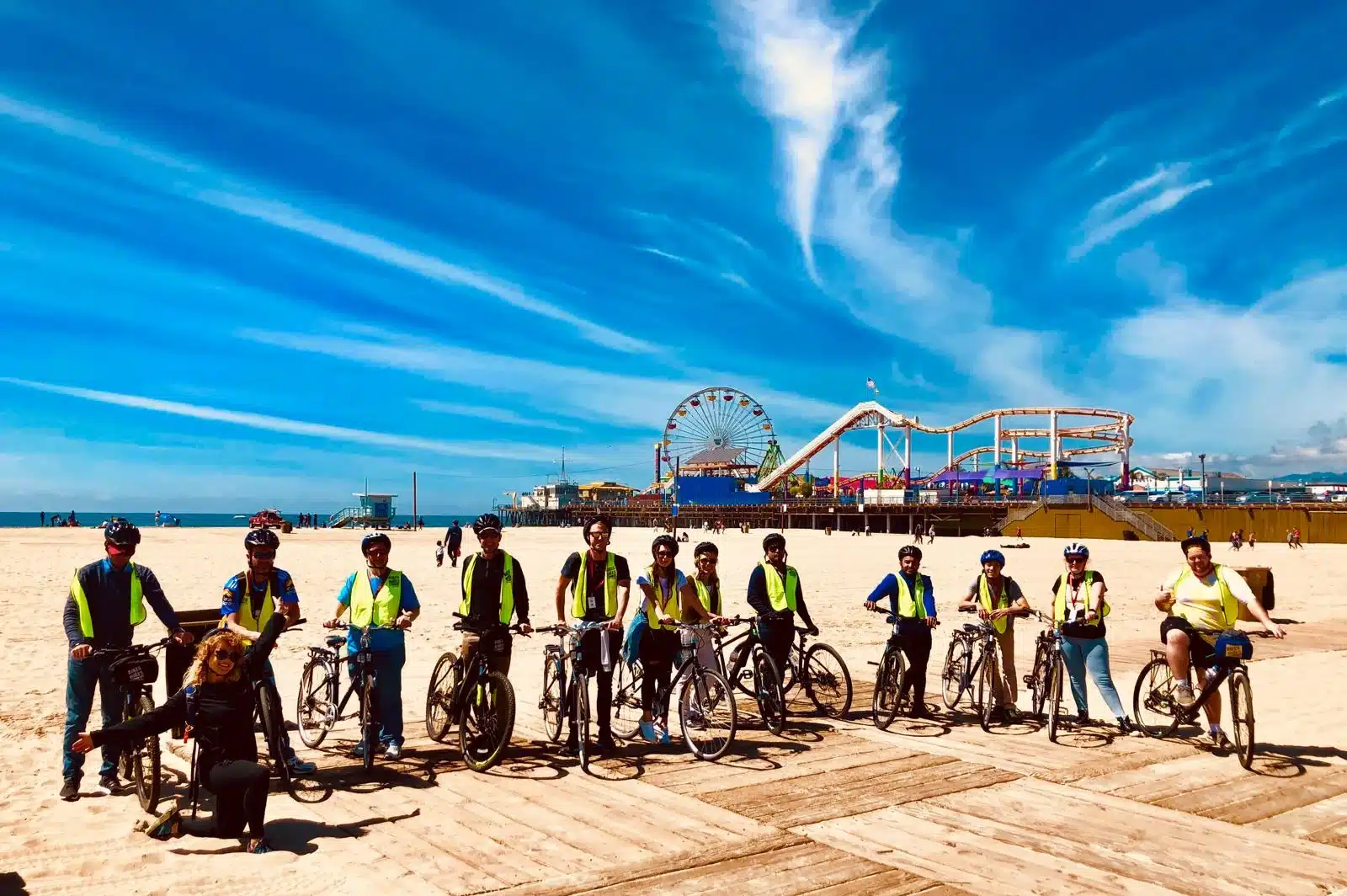 Guests pose with the santa monica pier on the santa monica and venice beach bike tour