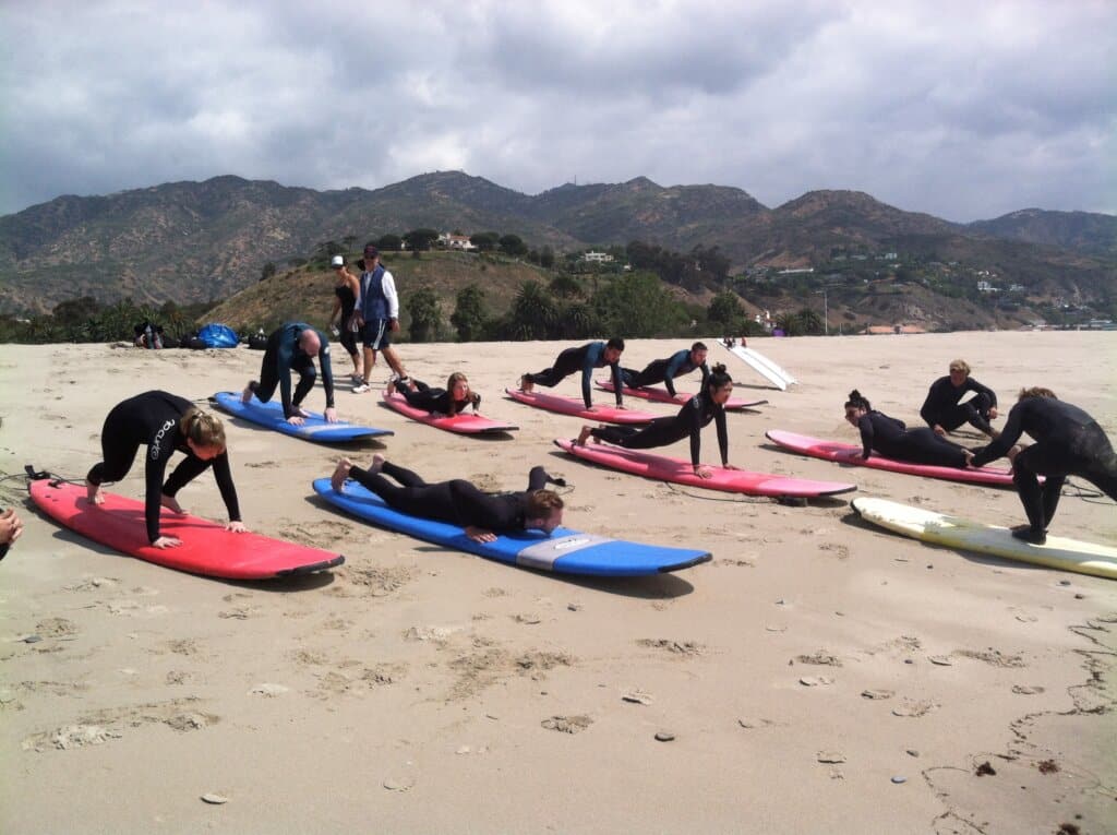 Surfers learning to paddle on land during our surf lesson with Bikes and Hikes LA