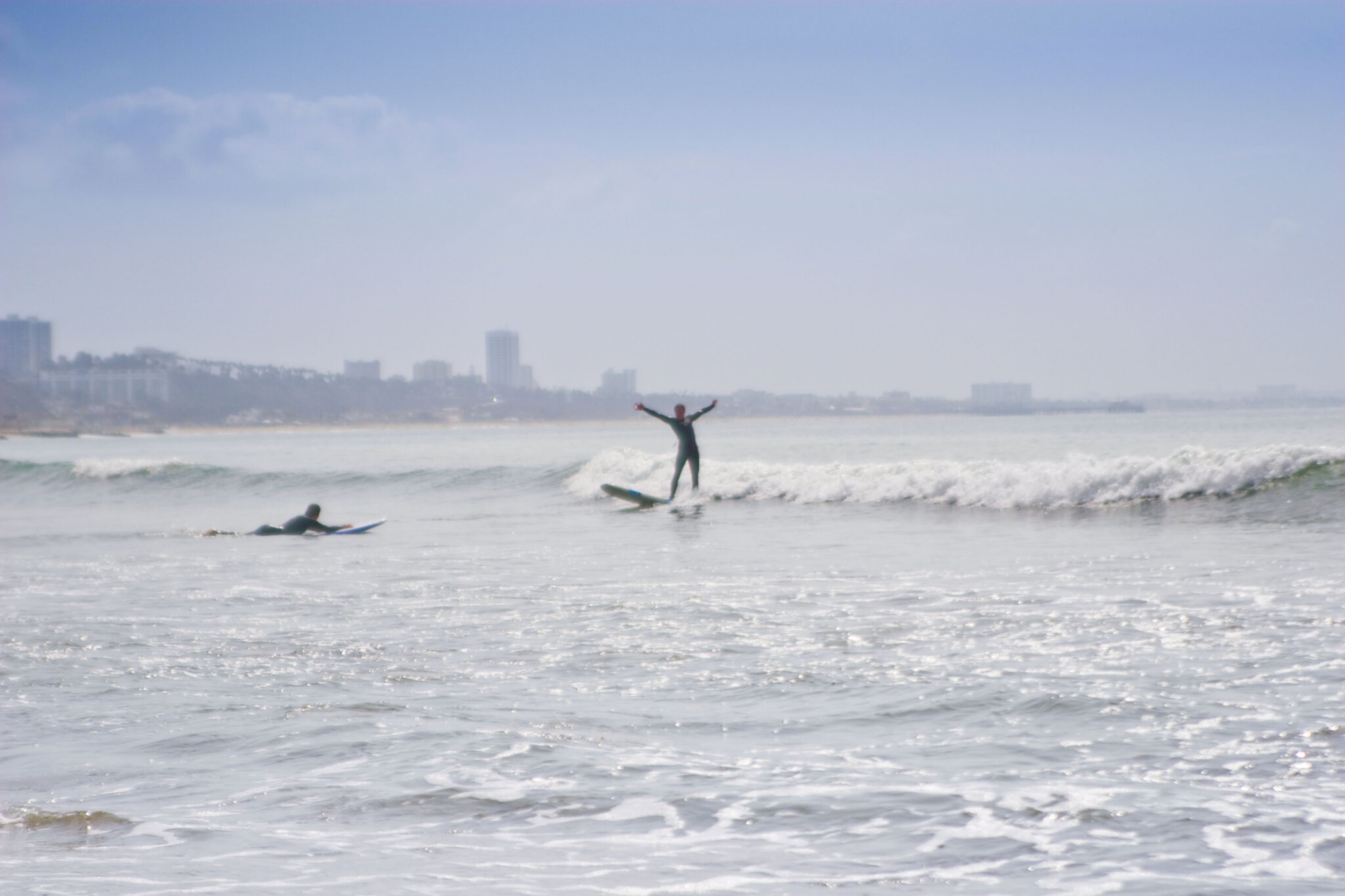 Surfers catching waves during a group surf lesson