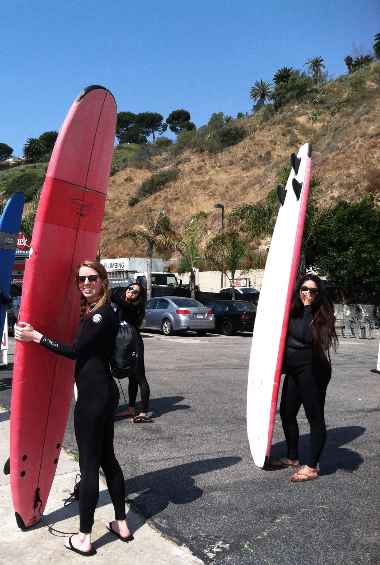 Big smiles with their boards during a group surf lesson