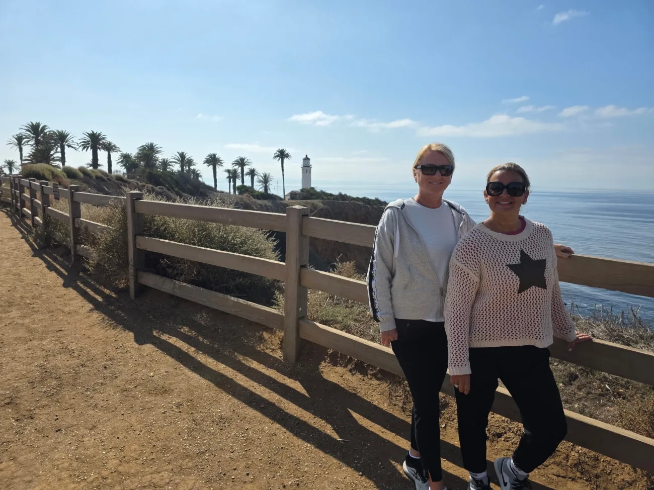 Guests standing along a coastal trail with Point Vicente Lighthouse in the background during a Palos Verdes nature walk