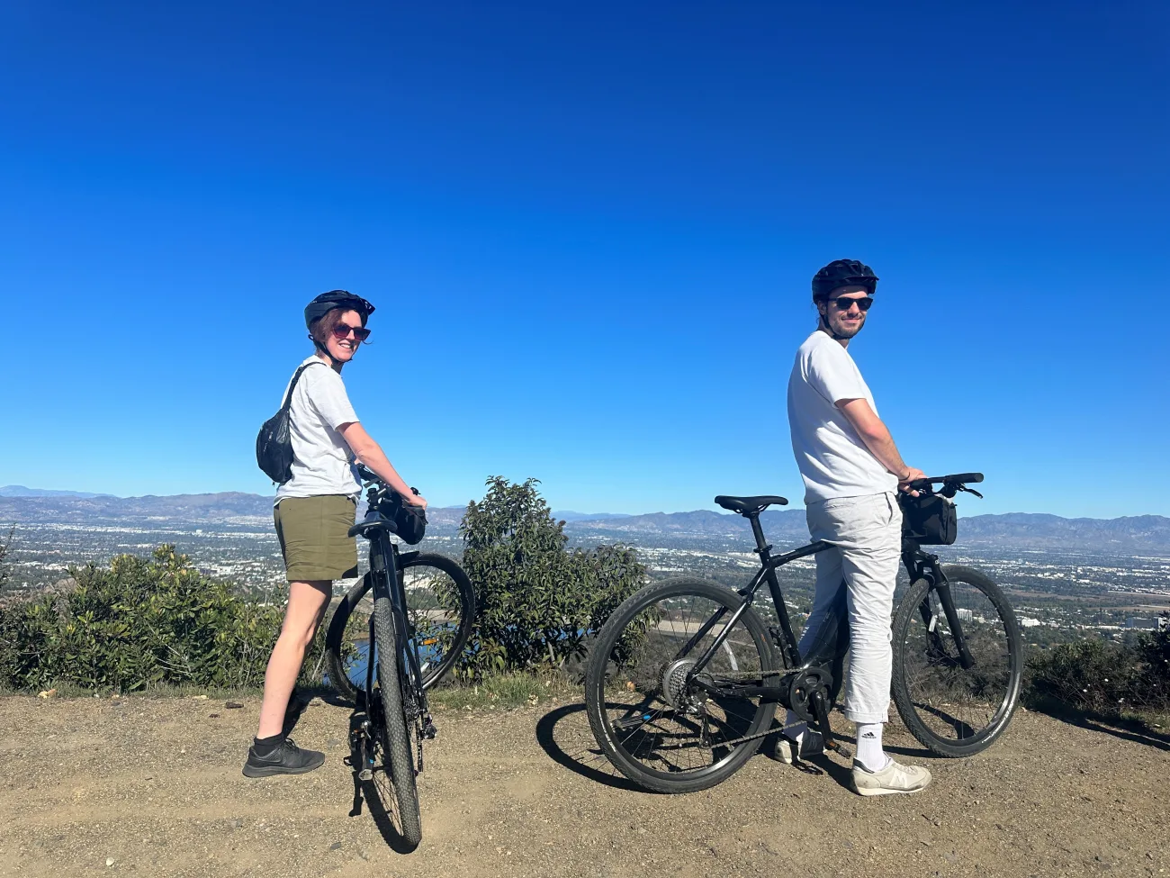 Guests standing on a hilltop overlooking a view with their bikes