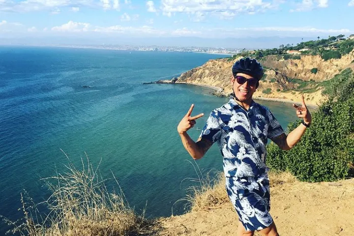 A guest poses with an ocean view in the background on the Terranea fitness bike tour