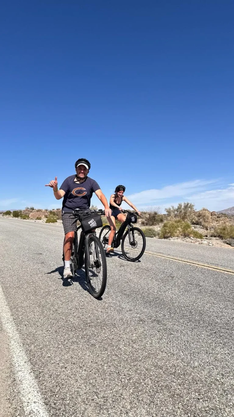 A man waves on a bike on the Joshua Tree Bike Tour
