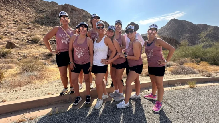 A group of bachelorette guests pose on a desert road during the Joshua Tree Bike Tour