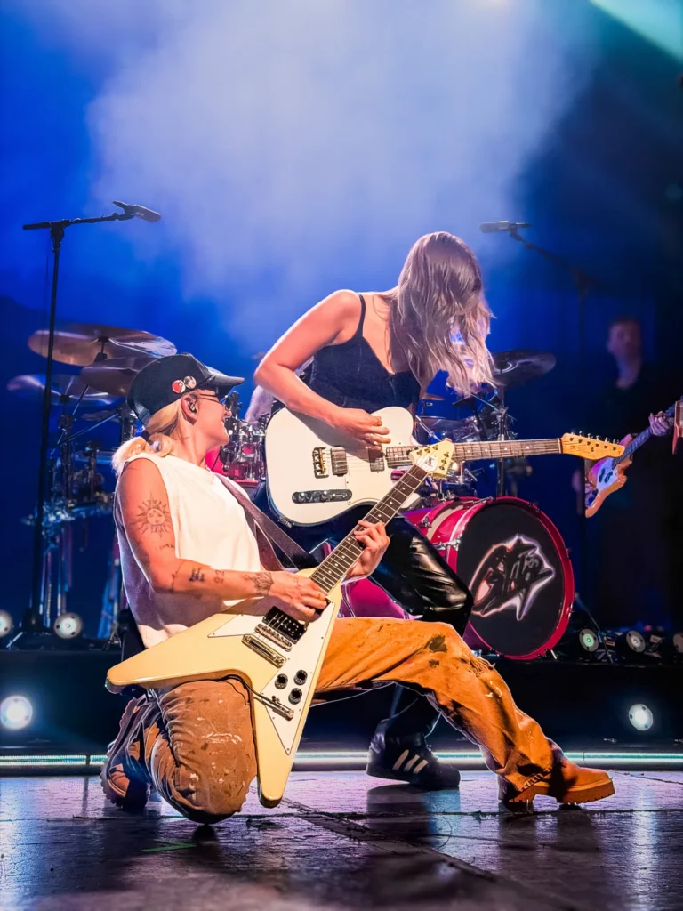 G Flip & Sophie Giuliani on stage playing guitars.