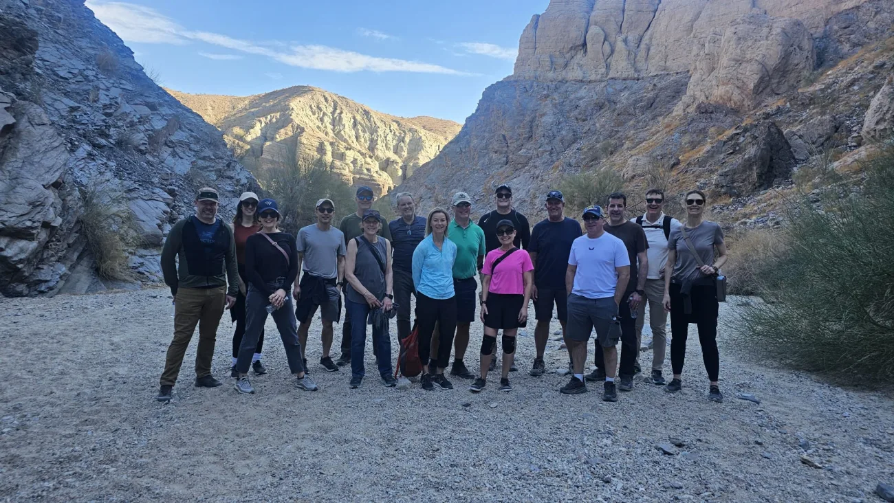Group standing in a scenic photo spot with mountains in the background