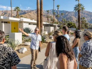 Guide points at homes on an architectural tour of palm Springs