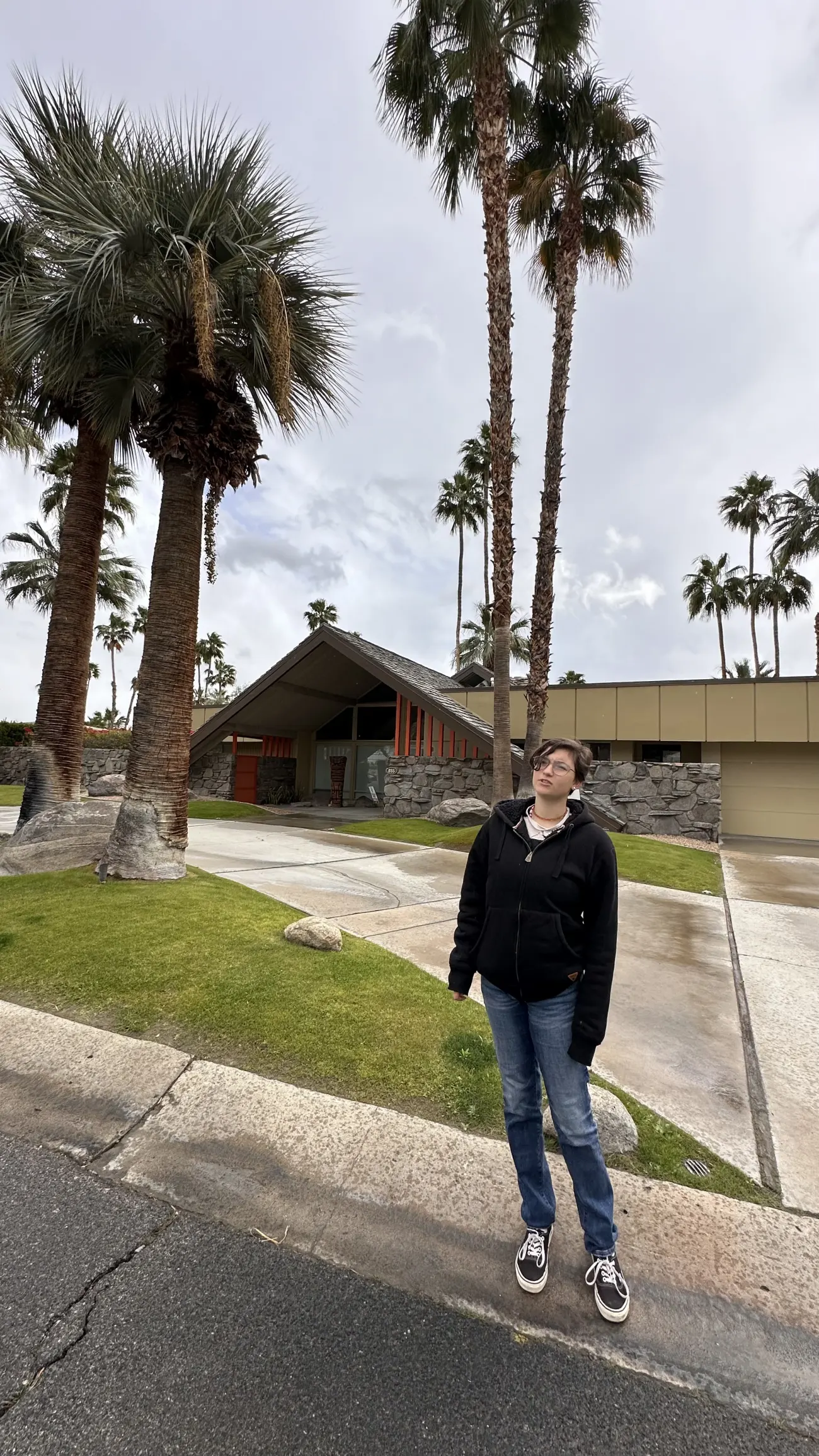 A guest stands in front of a mid century modern home