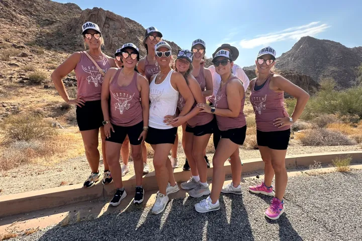 A bachelorette group poses with a rock formation on the Joshua Tree Hiking Tour