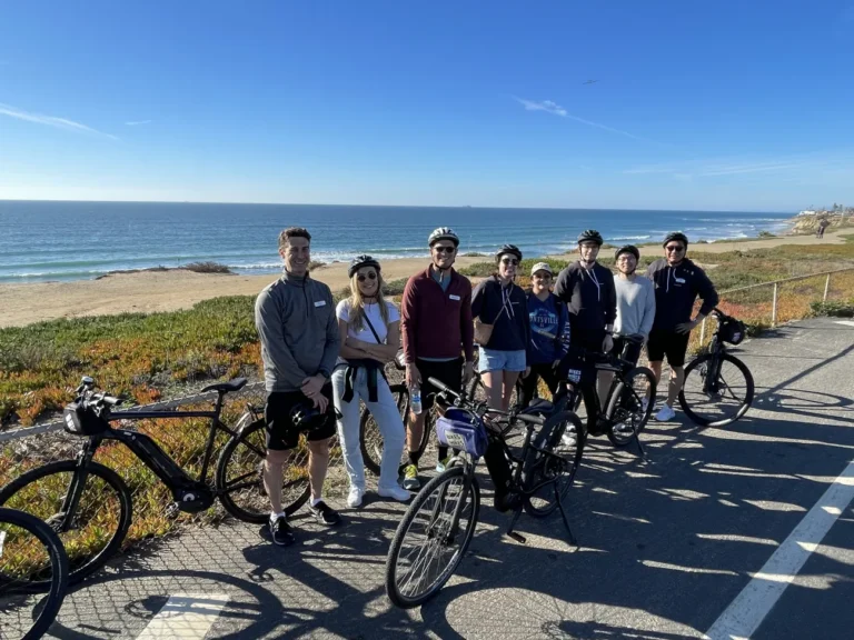 Guests pose in front of the ocean on a San Diego Bike Tour