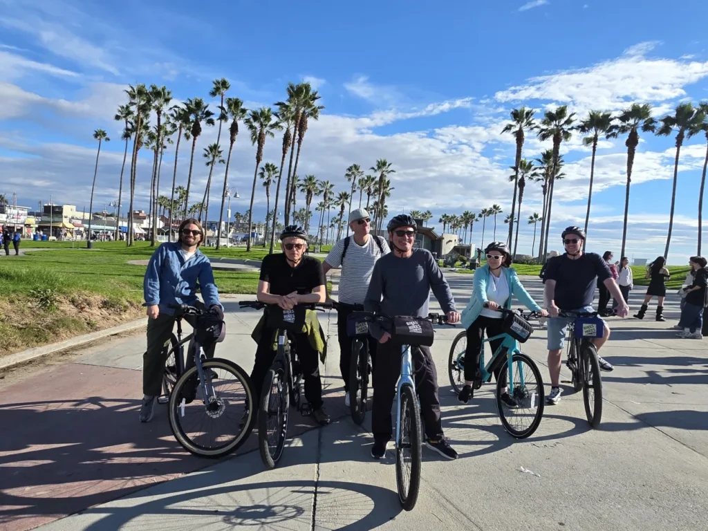 A group of guests pose on their bikes on the Santa Monica Bike Path