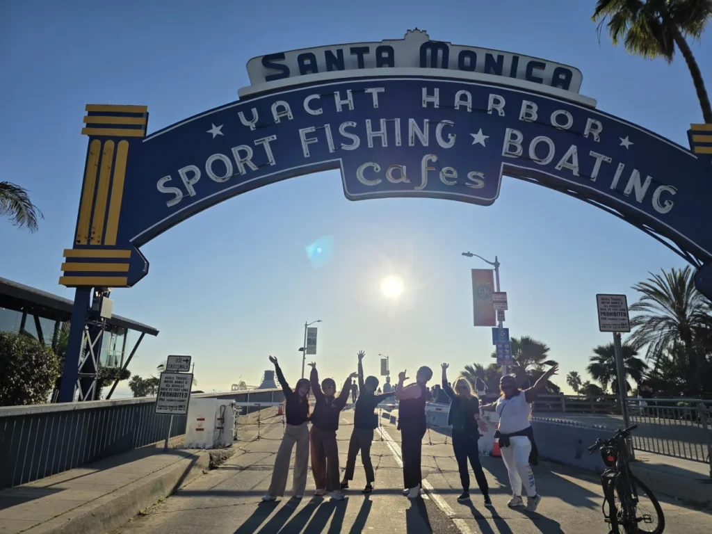 Guests pose under the entrance to the Santa Monica Pier