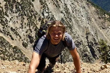 A guest climbs a rock on the solstice canyon hike