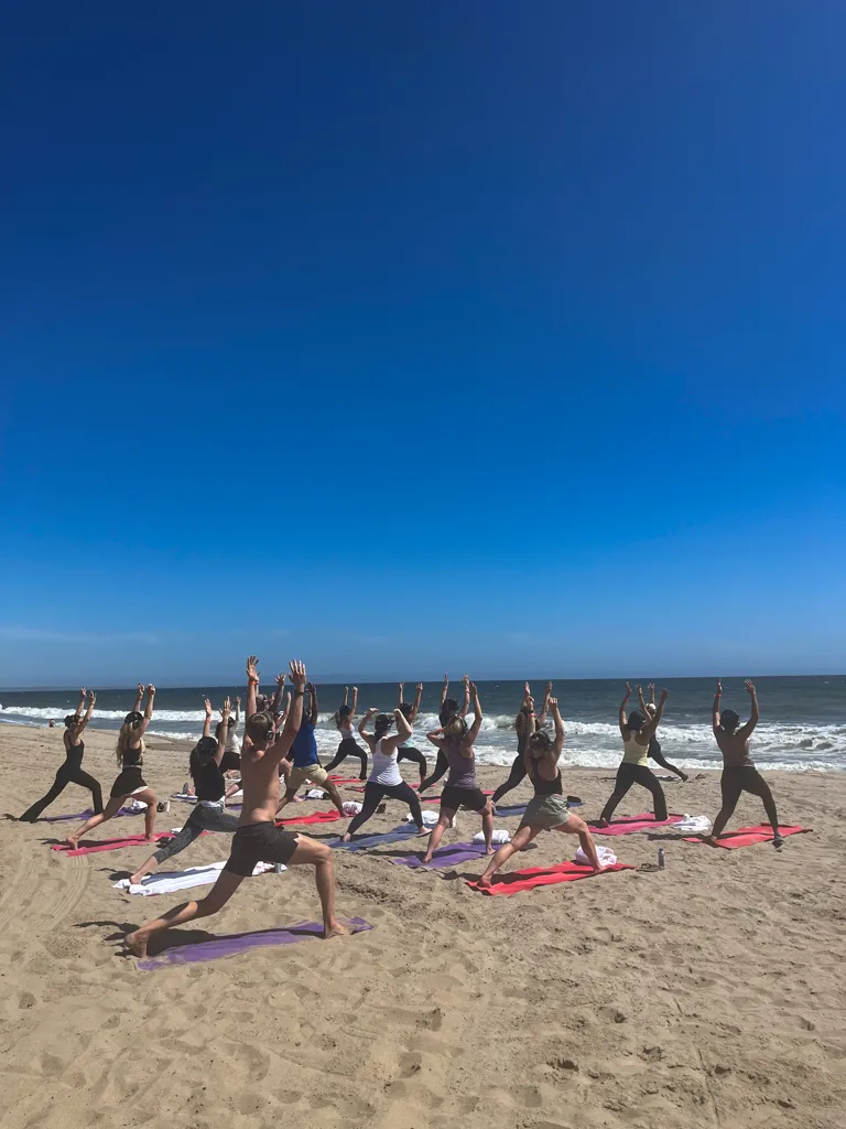 Clients pose during yoga on the beach