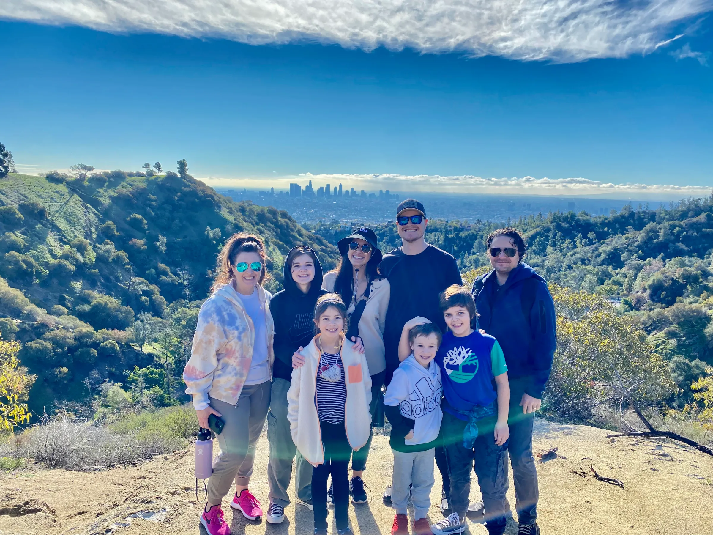 a group of people posing for a photo in front of a mountain
