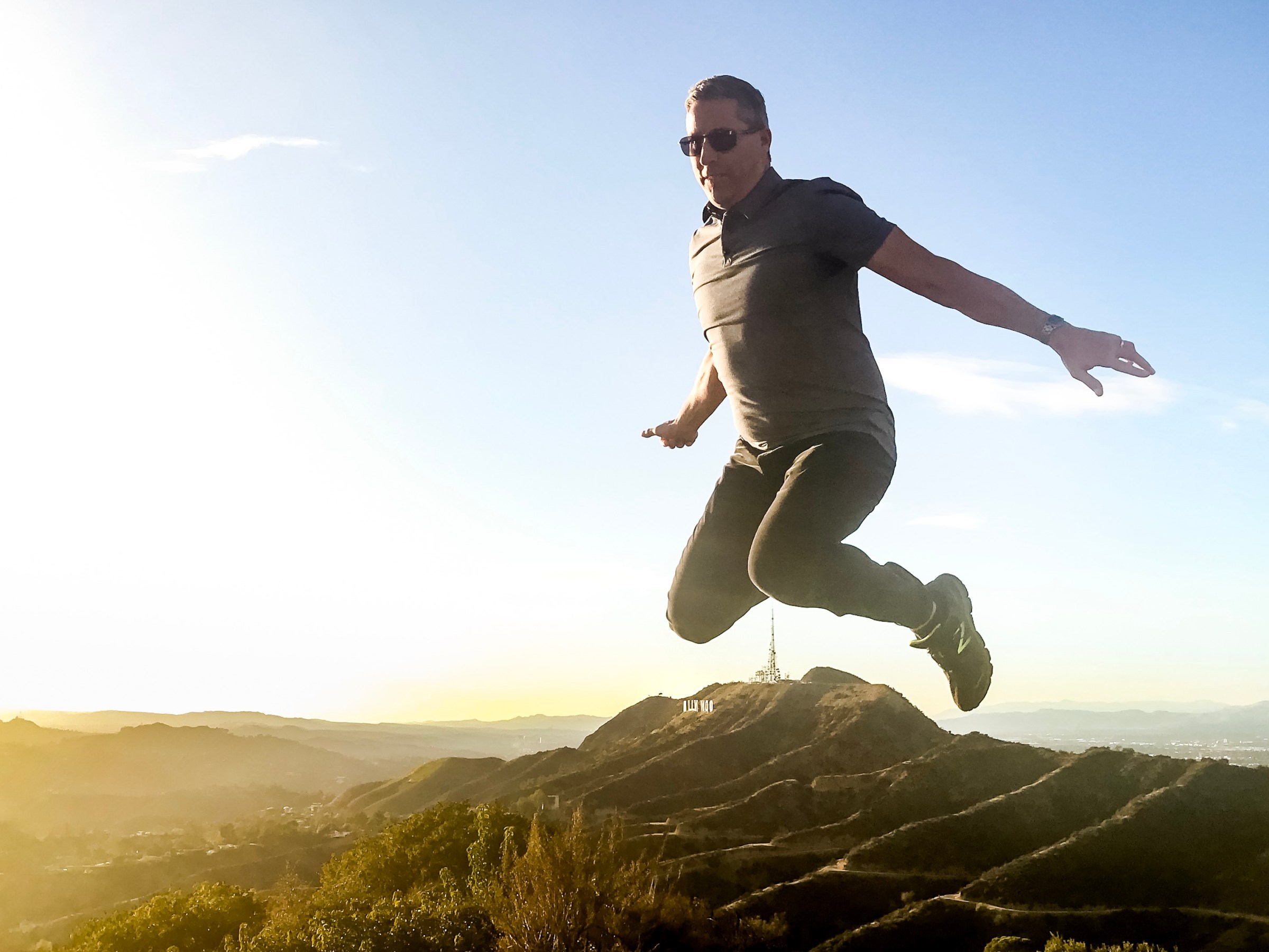 a man flying through the air on top of a mountain