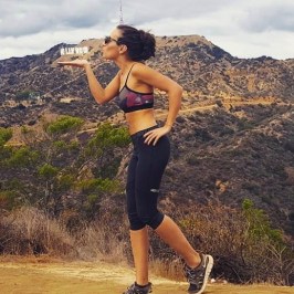 a woman standing in front of a mountain