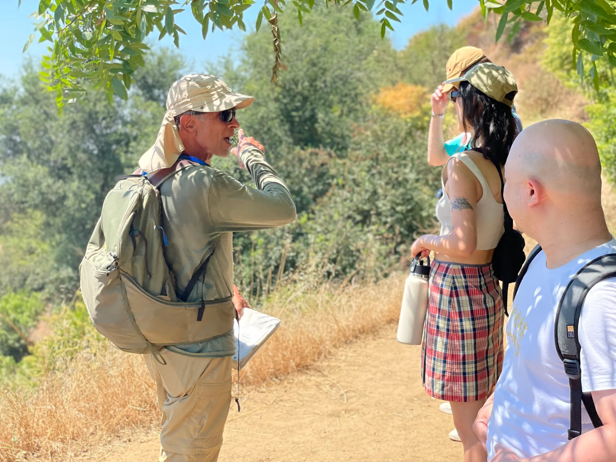 a group of people walking down a dirt road