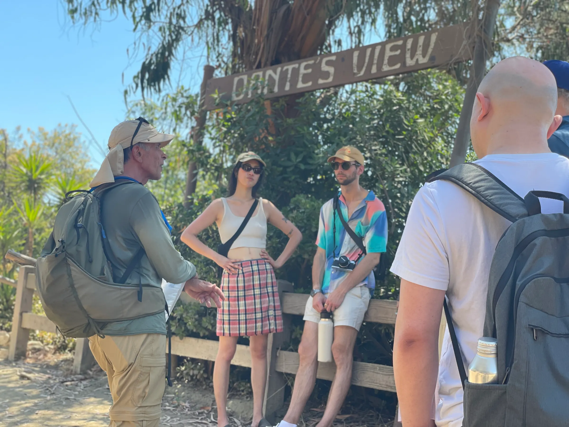 a group of people standing next to a tree