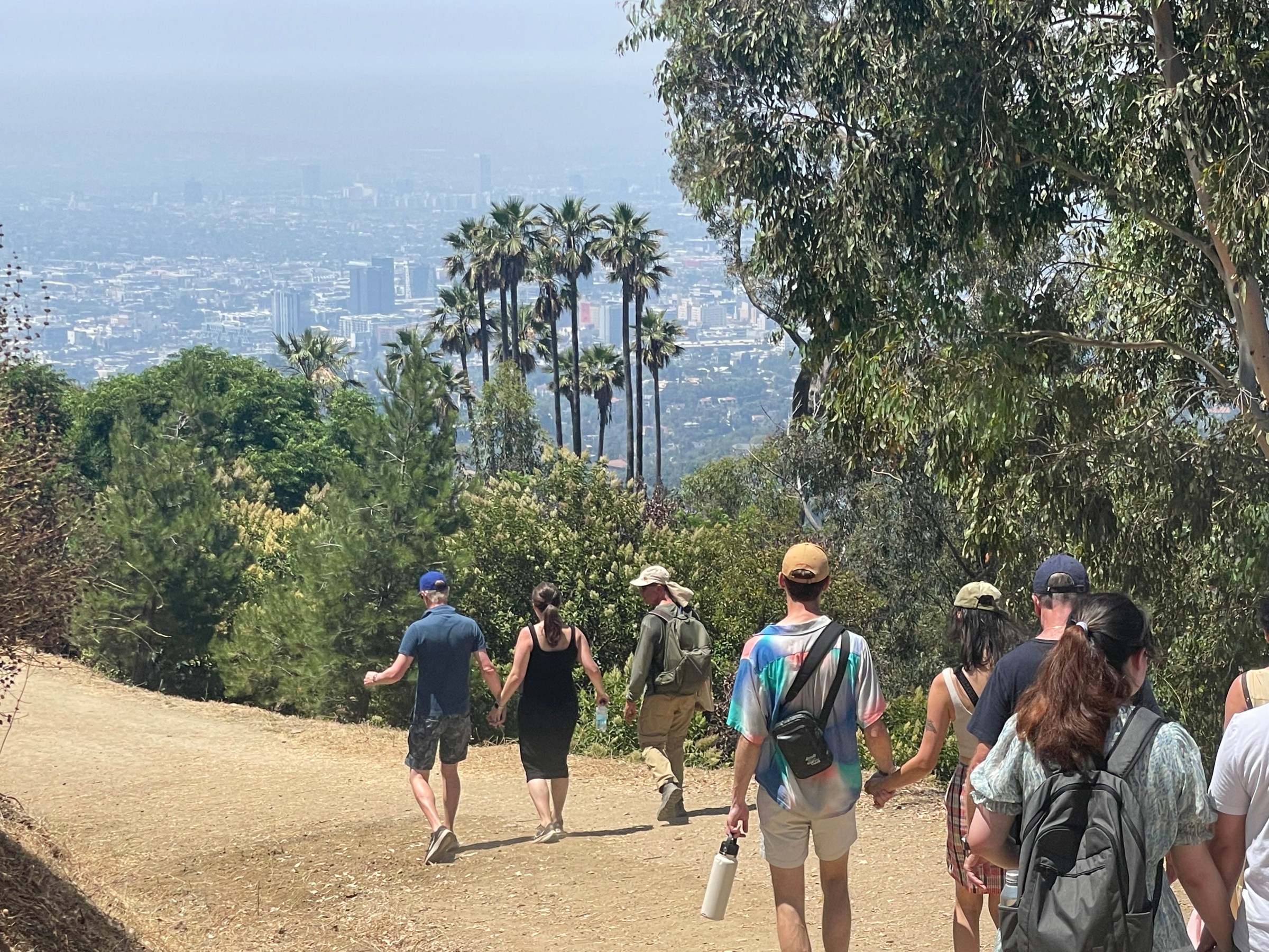 a group of people walking down a dirt road