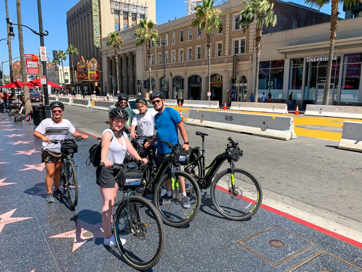 a group of people standing next to a bicycle