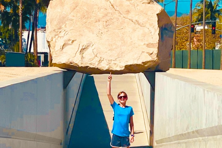 a woman holding up a rock at the hollywood forever cemetery