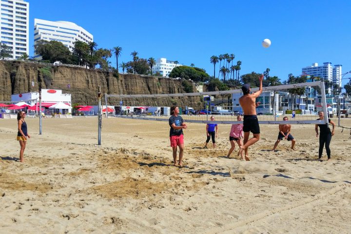 a group of people standing on top of a sandy beach
