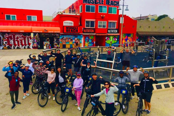 a group of people riding on the back of a bicycle