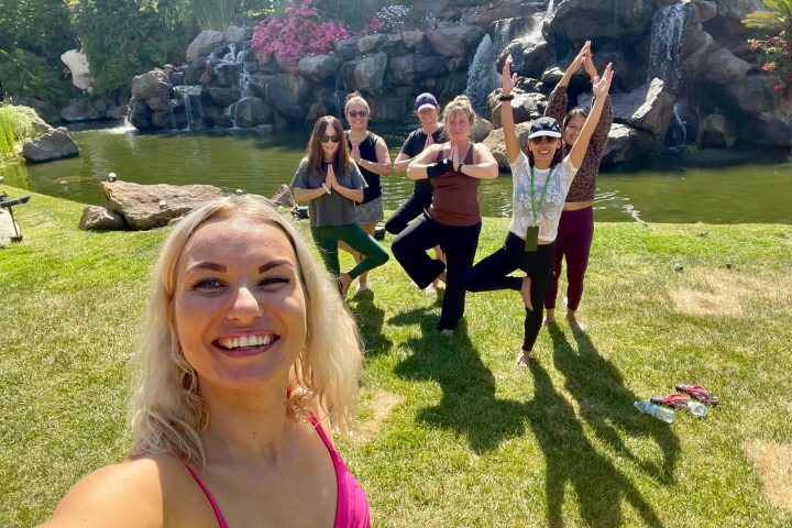 a group of people do yoga outside on a westlake team building outing