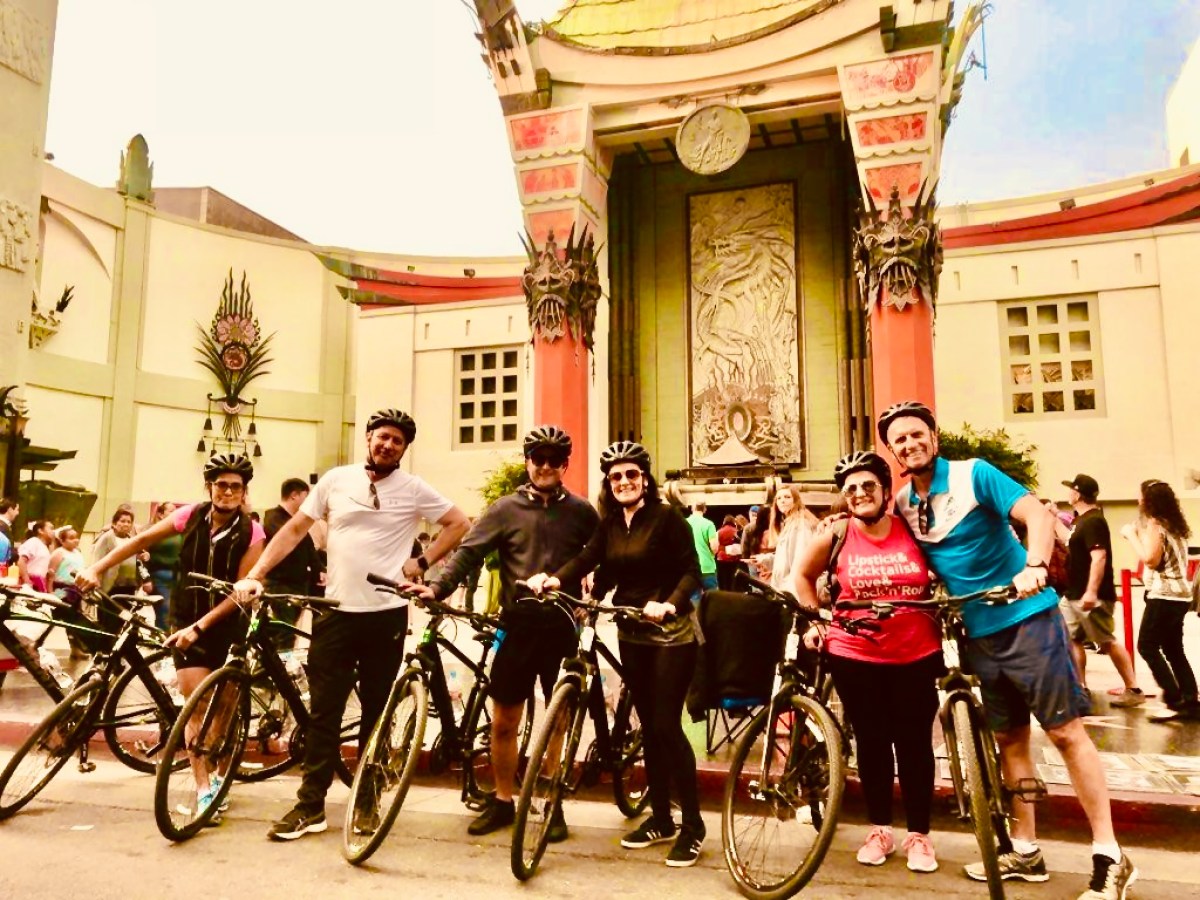 a group of people riding on the back of a bicycle