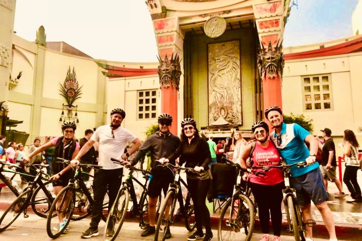 a group of people riding on the back of a bicycle
