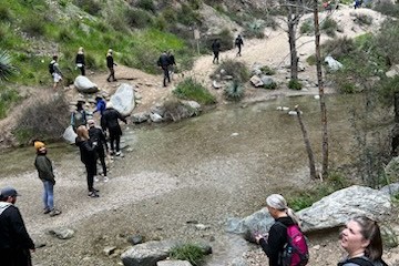 a group of people walking down a dirt road